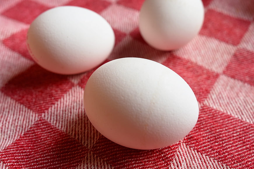 Three Fresh White Eggs On Red Checkered Kitchen Cloth