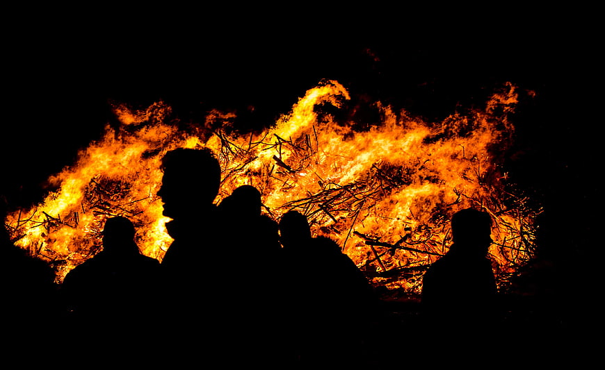 Silhouettes of People Watching a Large Bonfire at Night
