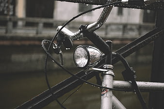 Close-up of wet vintage bicycle handlebars and headlight in rain