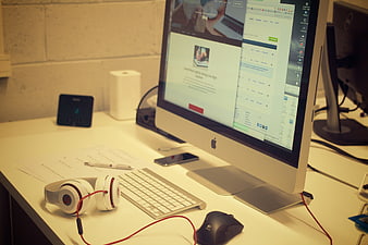 Modern office desk with iMac, headphones, and workspace essentials