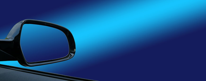 Car Side Mirror Against Blue Gradient Background