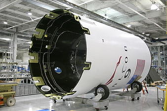 Unfinished rocket fuselage with US flag in aerospace factory