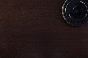 Camera Lens on Dark Wooden Desk Background