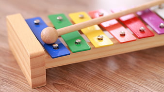 Colorful wooden xylophone toy with mallet on table