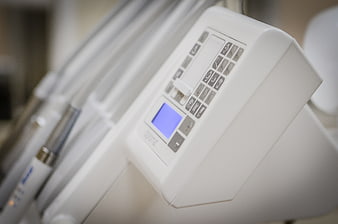 Close-up of white dental equipment control panel with blue screen
