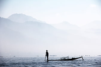 Silhouette of Inle Lake Fisherman Rowing in Foggy Morning