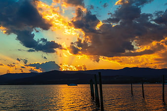 Dramatic Golden Sunset Over Tasmanian Water with Silhouetted Mountains