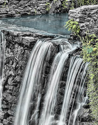 Selective Color Waterfall Cascading Over Dark Rocks