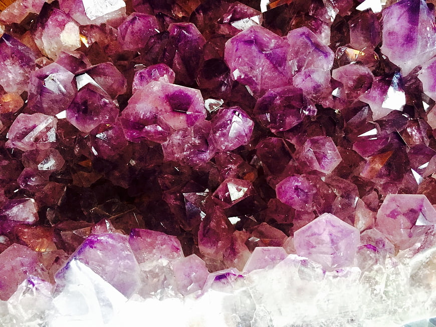 Close-up of purple amethyst crystal cluster with white quartz base