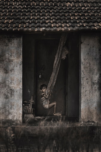 Child Swinging on Cloth Hammock in Rural Village