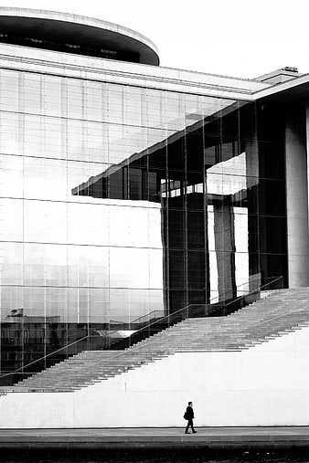 Black and white modern architecture with glass facade and walking man