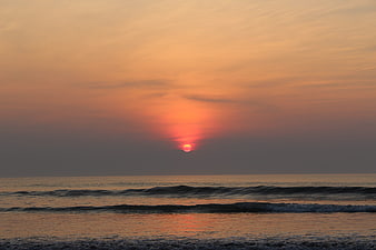 Serene Sunset Over Ocean Waves with Golden Sky Reflection