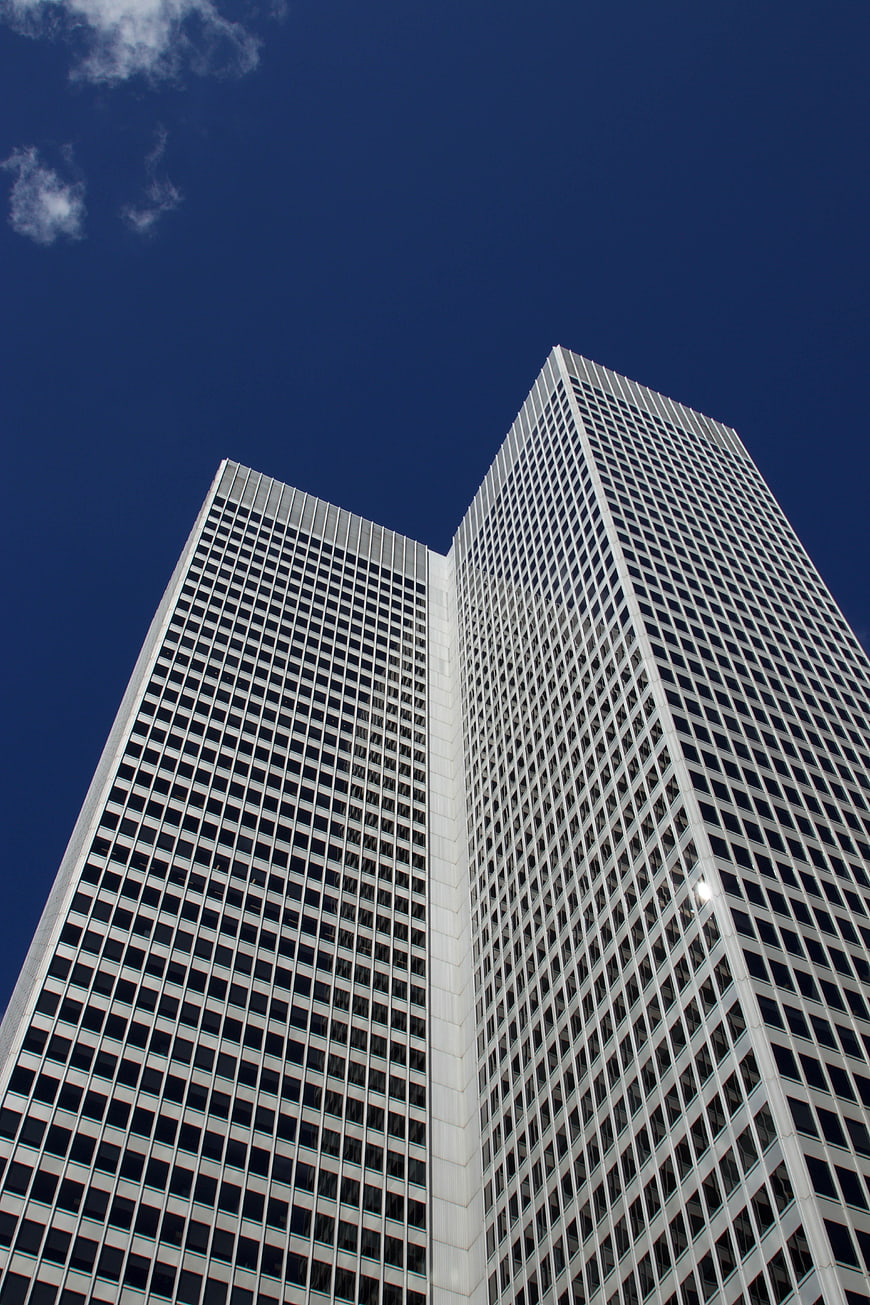 Low angle view of modern skyscrapers against blue sky
