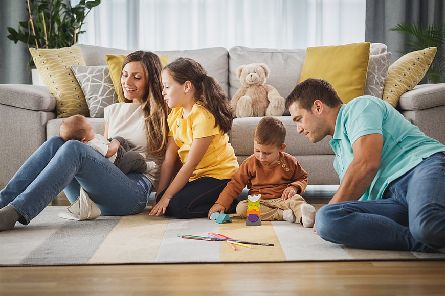 Happy family playing with toys on living room floor