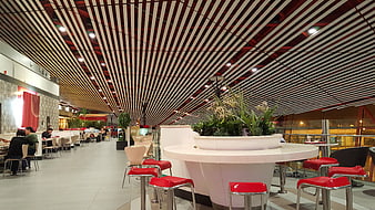 Modern Airport Lounge Interior With Red Seating And Slatted Ceiling