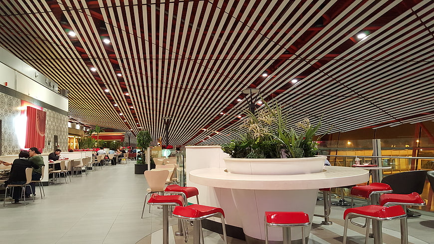Modern Airport Lounge Interior With Red Seating And Slatted Ceiling