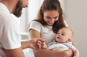 Happy Parents Holding Newborn Baby at Home