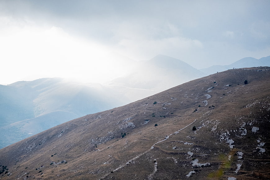 Misty Mountain Ridge with Sunlight Breaking Through Clouds