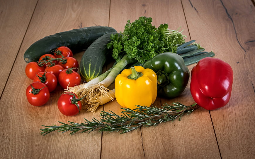 Fresh organic vegetables and herbs on wooden table