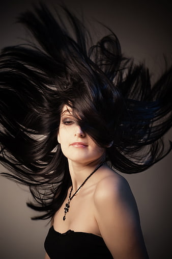 Dramatic portrait of woman with flying black hair