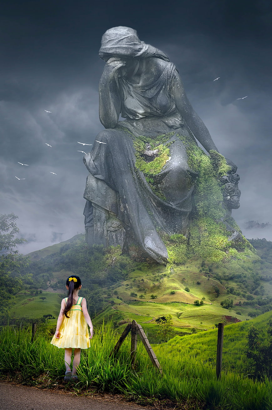 Surreal fantasy landscape with giant weeping statue and little girl