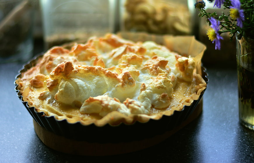 Rustic Meringue Topped Tart With Purple Flowers On Dark Table