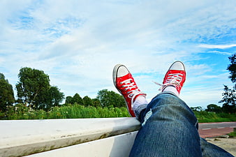 Red Sneakers on Bench Against Blue Sky