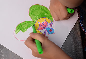 Child drawing colorful picture with green marker
