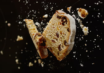 Traditional Christmas Stollen with Powdered Sugar on Black Background