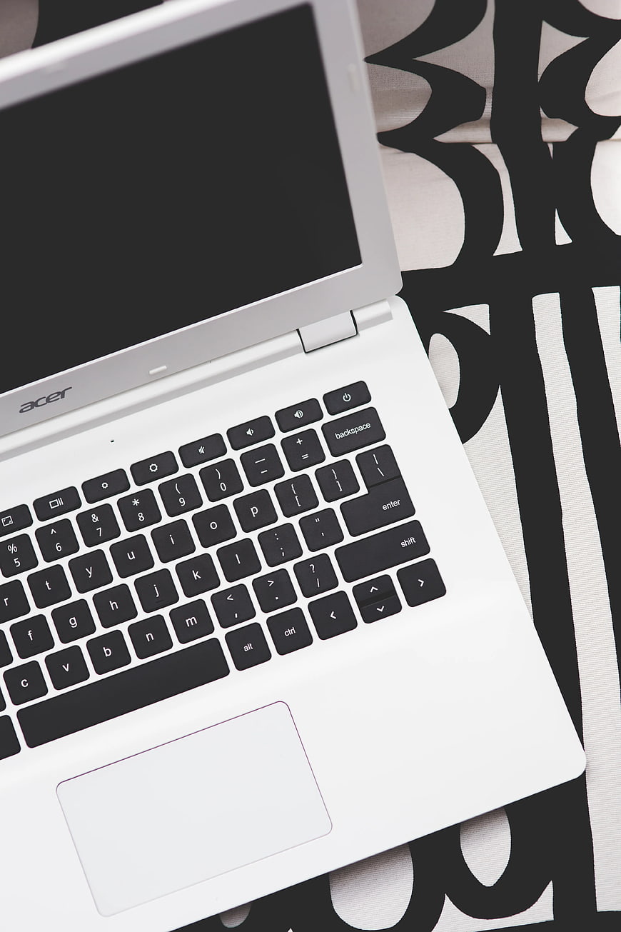 White Acer laptop on black and white patterned background