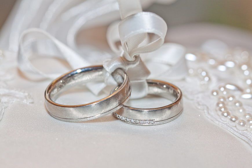 Silver Wedding Rings with Diamonds on White Lace and Ribbon