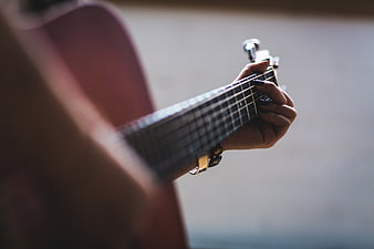 Close-up of woman playing acoustic guitar chords