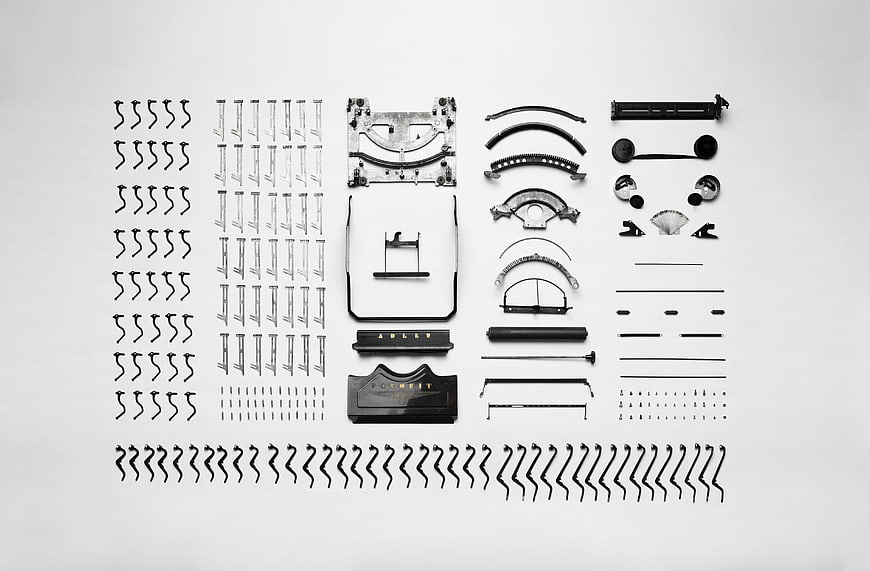 Disassembled vintage typewriter parts arranged in flat lay