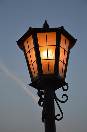 Vintage Street Lamp Glowing Against Blue Sky