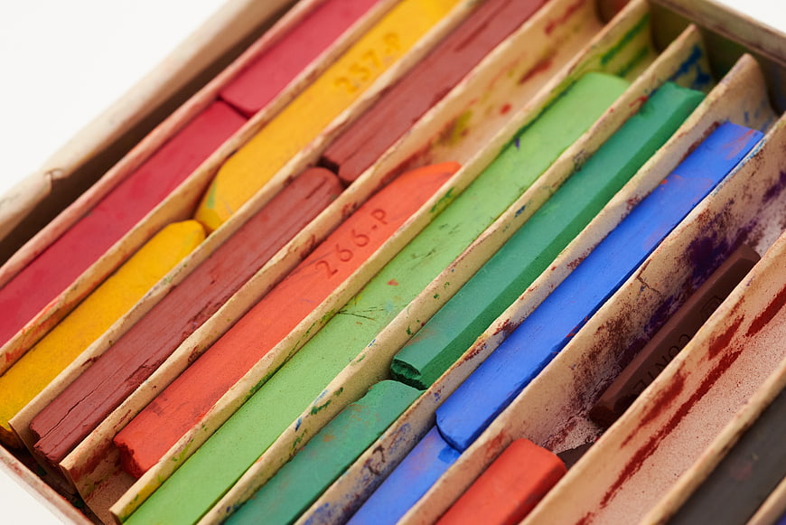 Close-up of colorful chalk pastels in a cardboard box
