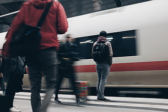 Man waiting on subway platform as train passes by