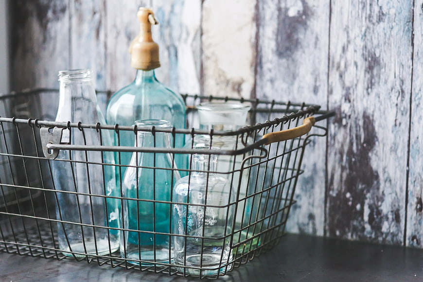 Vintage glass bottles in rustic wire basket