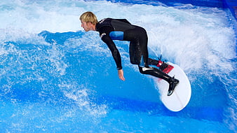 Surfer performing a dynamic maneuver on a wave in a wetsuit