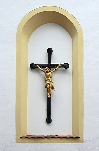 Golden Crucifix in Arched Niche on White Church Wall