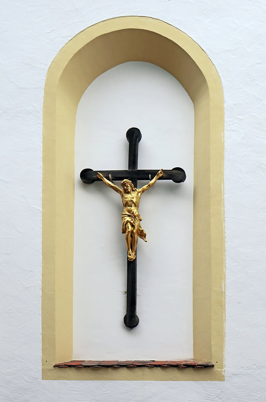 Golden Crucifix in Arched Niche on White Church Wall