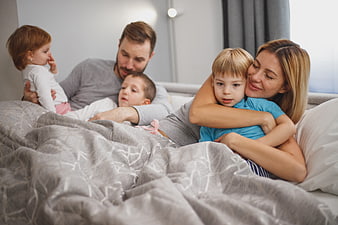 Happy family relaxing together in bed on a lazy morning