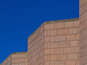 Modern granite building facade against deep blue sky