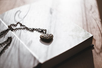 Vintage Heart Locket Necklace on Open Book