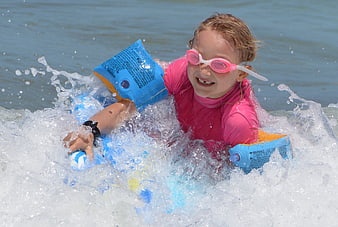 Happy Girl Surfing with Floaties and Goggles
