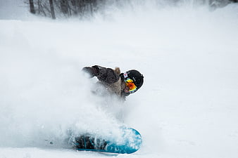 Snowboarder carving through deep powder snow