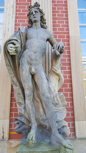 Classical Stone Statue of Nude Male Figure on Brick Building