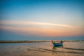 Longtail boat on tropical beach at sunset