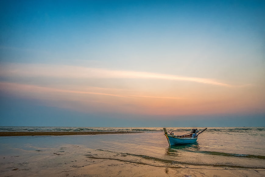 Longtail boat on tropical beach at sunset