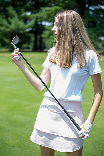 Young Woman Golfer Holding Club on Green Course