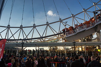 Crowd Waiting Under Large Ferris Wheel Structure